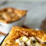Individual chicken pie in a ramekin crust open to reveal filling.