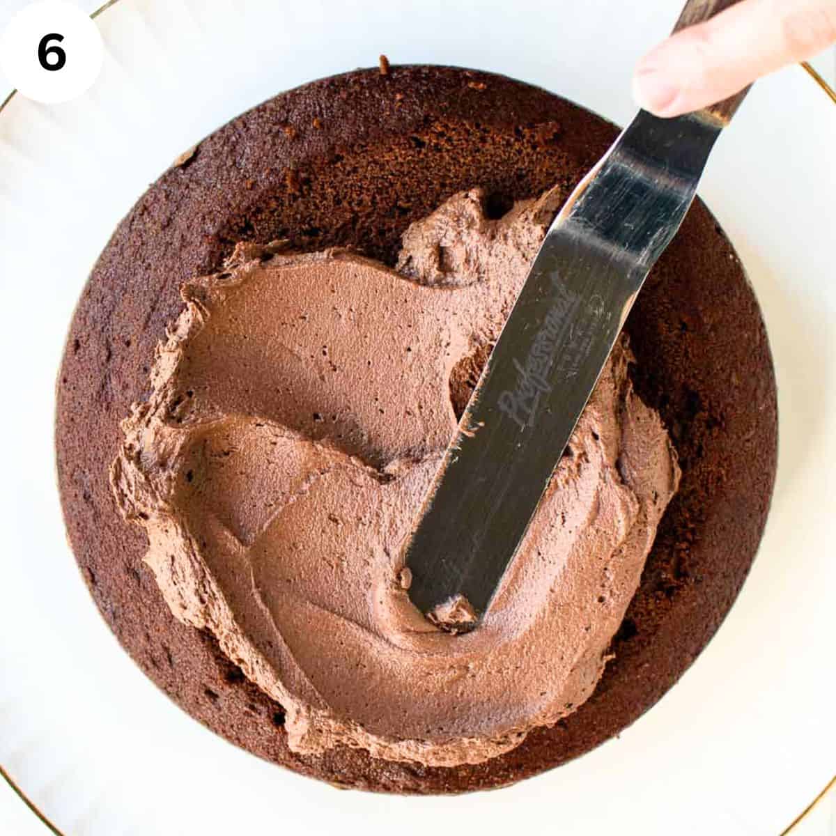 Chocolate frosting being spread onto chocolate cake.