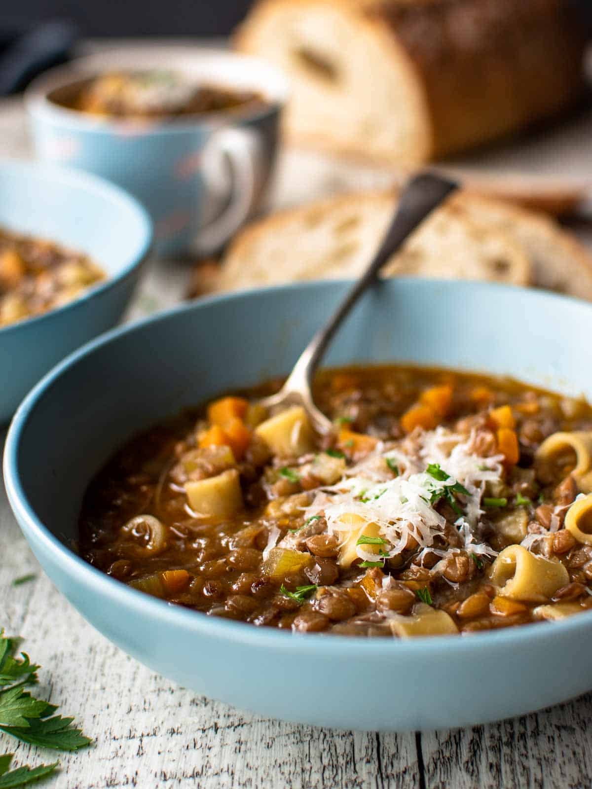 Blue bowl filled with Mediterranean lentil soup.