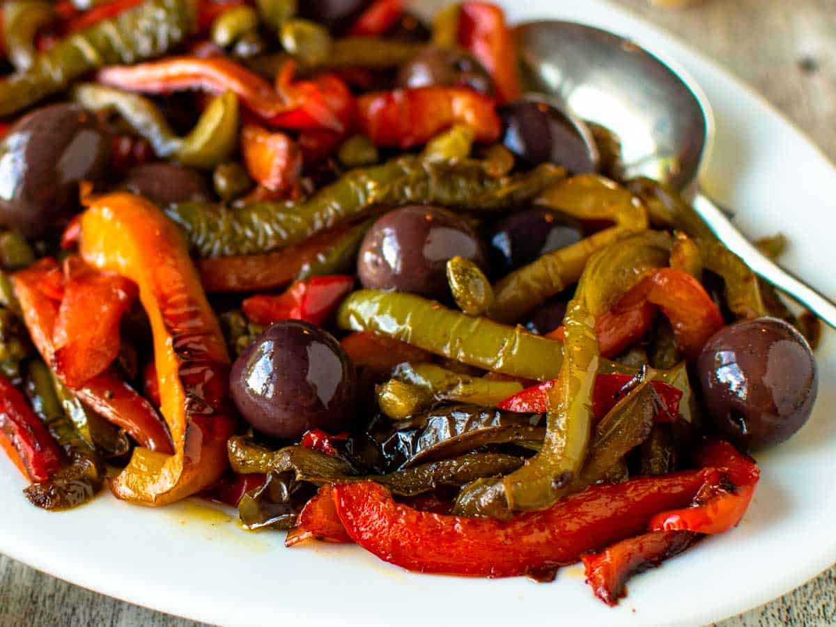 Close up of fried multi colored peppers on a white plate.
