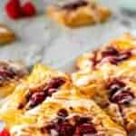 Raspberry Danish pastries on white plate.