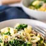 Pasta with broccolini and sausage in a grey bowl.