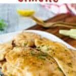 Chicken Limone on a white plate garnished with chopped parsley.