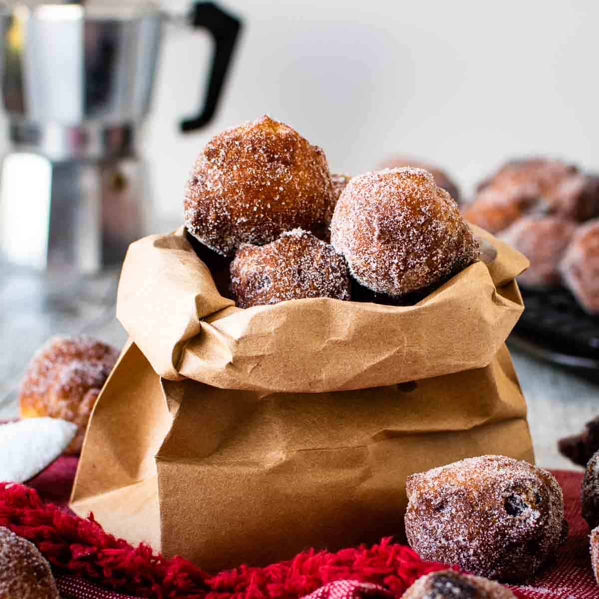 Frittelle coated in sugar in a brown paper bag.