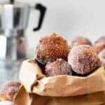 Frittelle coated in sugar in a brown paper bag.