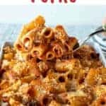 Pasta al forno in a white baking dish with a scoopful lifted up.