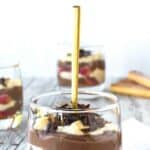 Zuppa Inglese in a glass with a gold spoon standing upright in the dessert.