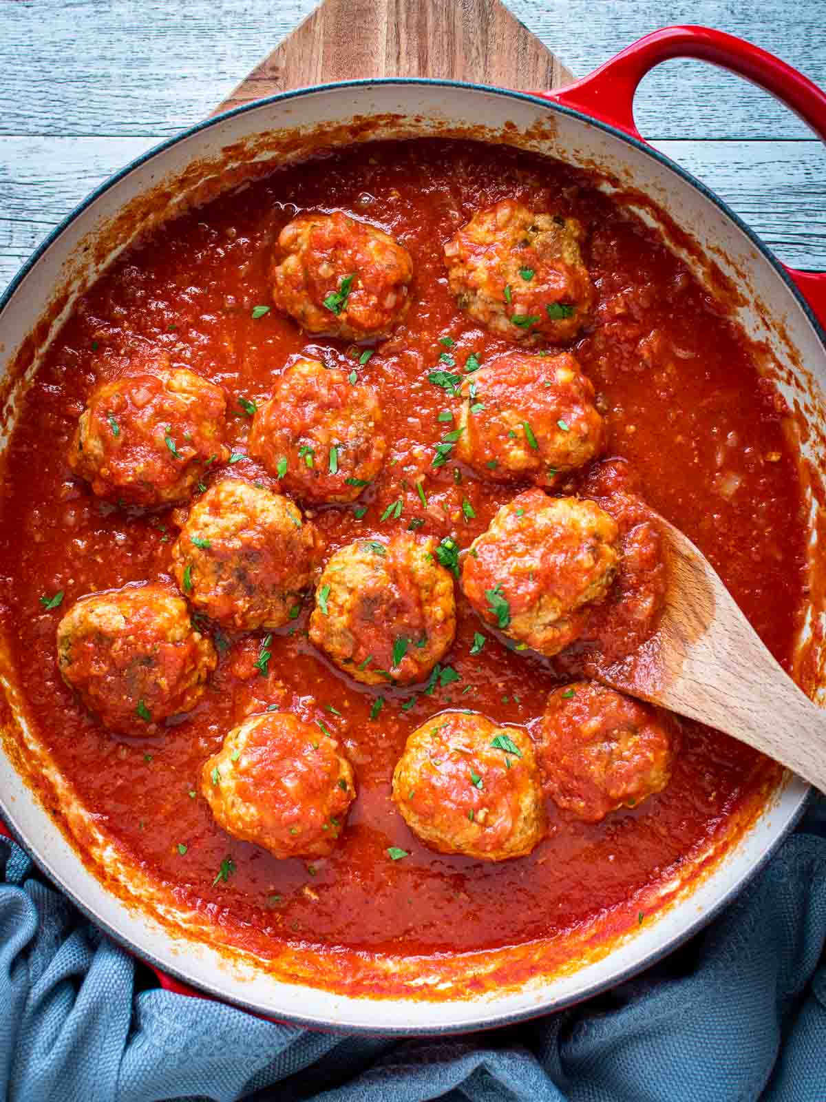 Italian Sausage Meatballs in tomato sauce in a pan viewed from above.