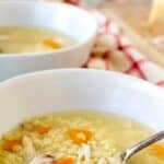 Chicken Pastina Soup in a white bowl with second bowl in the background.