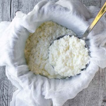 Curds being scooped in to cheesecloth lined colander.