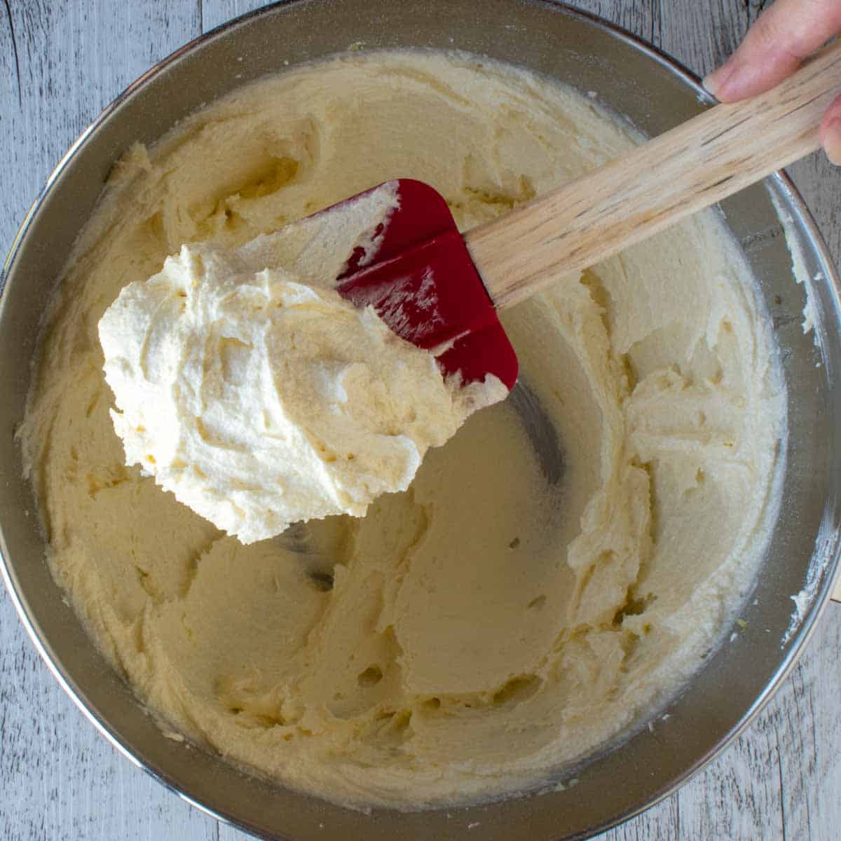 Close up of beaten butter and sugar on a red spatula.