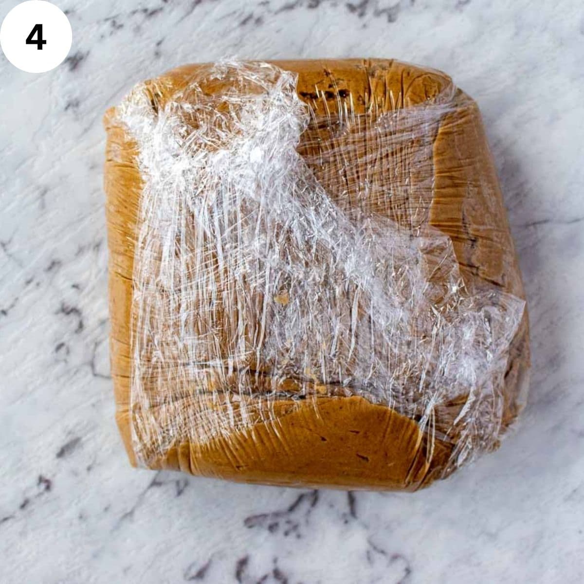 Brown cookie dough wrapped in plastic.