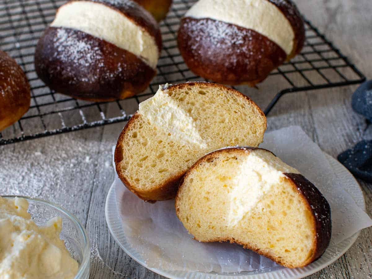 Close up of a filled brown bun cut in half revealing the cream filling.