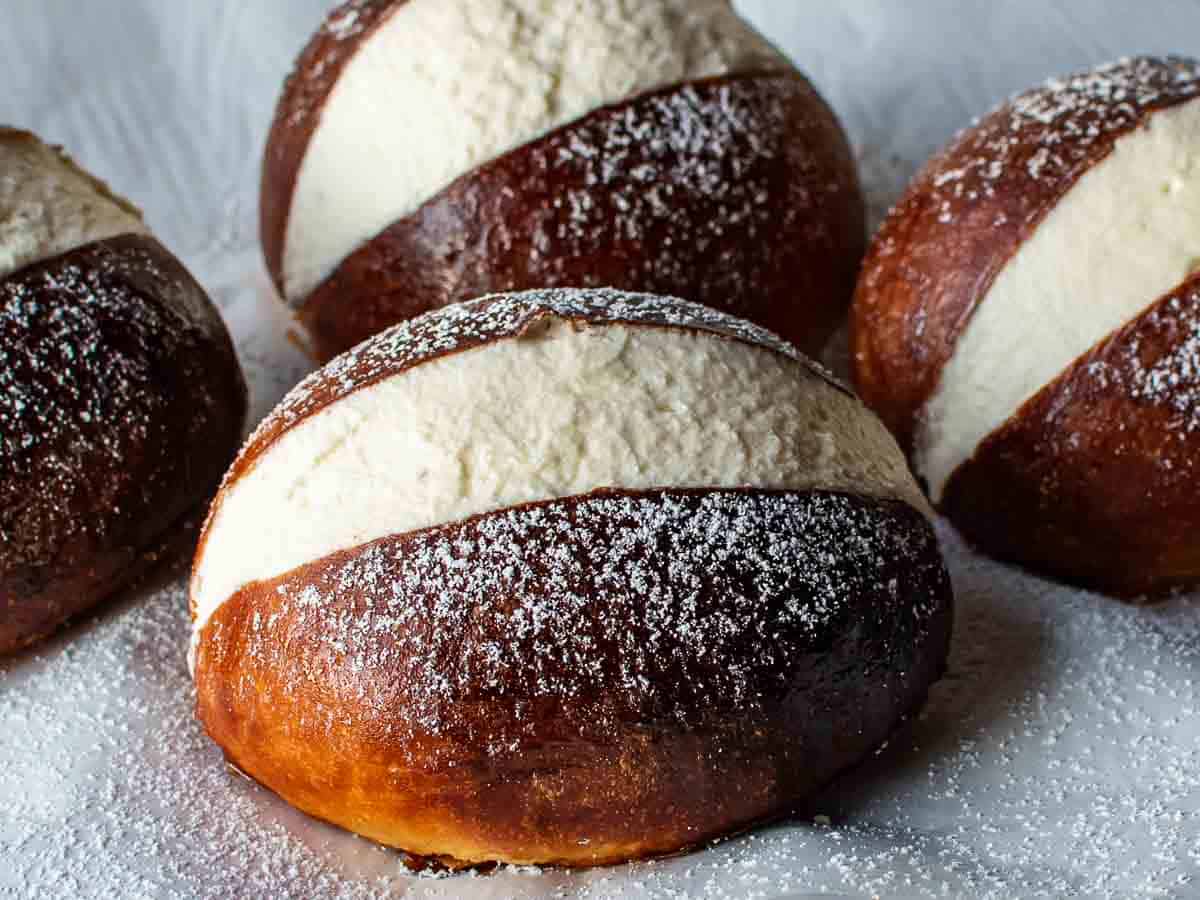 Close up of sweet browned but cut vertically and filled with cream