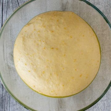 Pale yellow dough in the bottom of a glass bowl.