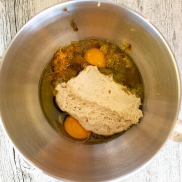 Spongy dough in a steel bowl with eggs and other liquids.