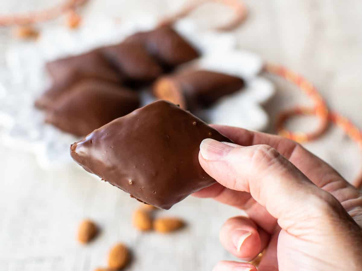 Close up of chocolate coated, diamond shaped cookie.