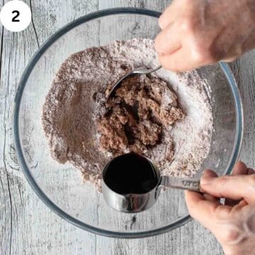 Dark colored liquid being added to dry ingredients.