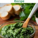 Italian salsa verde in a glass bowl with a painted wooden spoon in it.