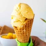 Mango gelato in a waffle cone.