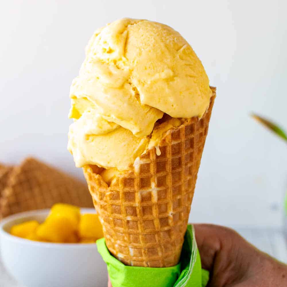 Mango gelato in a waffle cone.