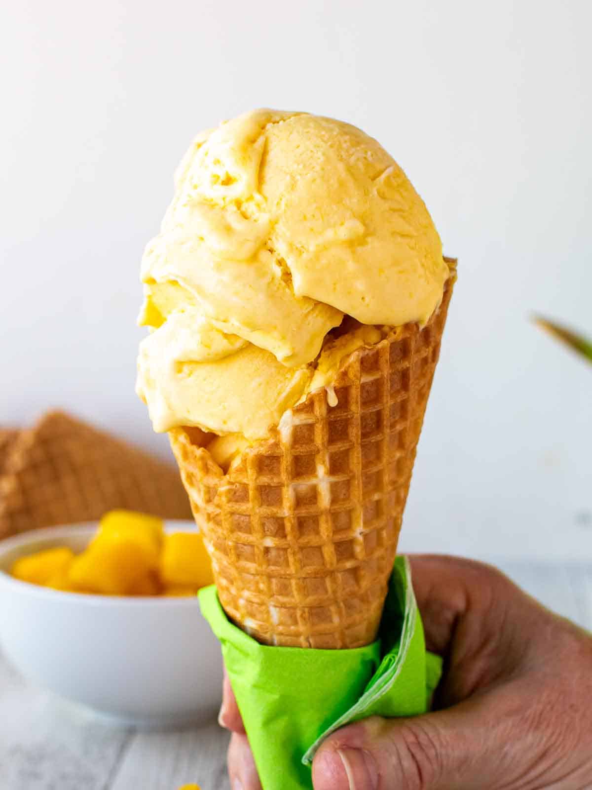 Mango gelato in a waffle cone.