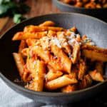 Chicken and Vodka Pasta in a shallow bowl with another bowl in the background.