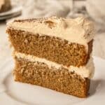 Close up of a wedge of two layer cake filled and topped with buttercream.