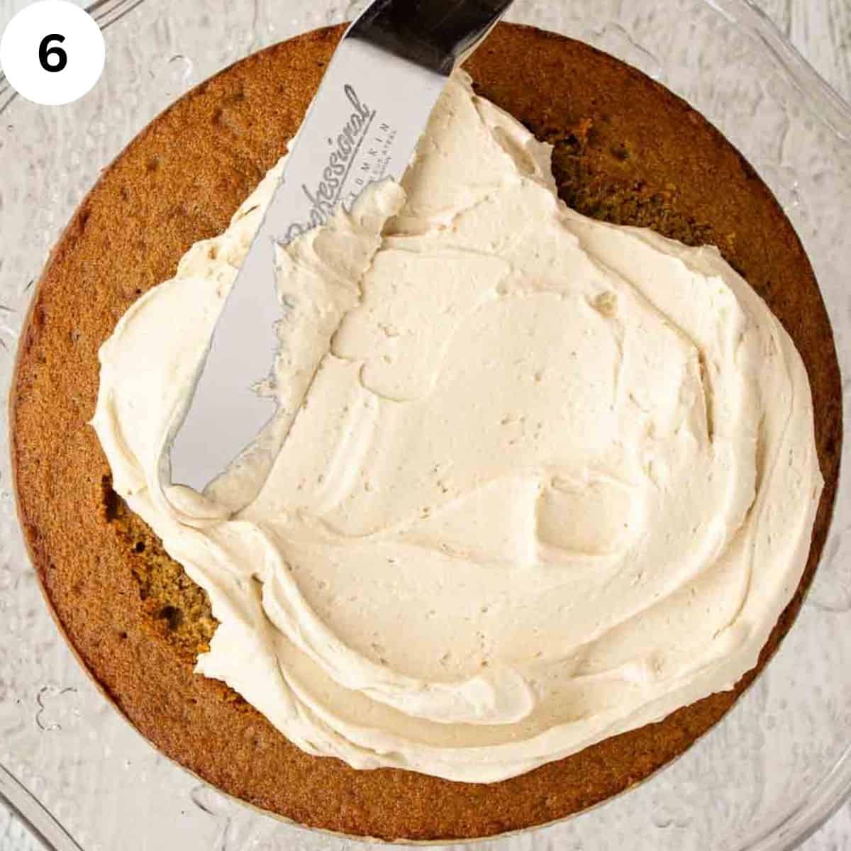 Buttercream being spread on a cake with a palette knife.