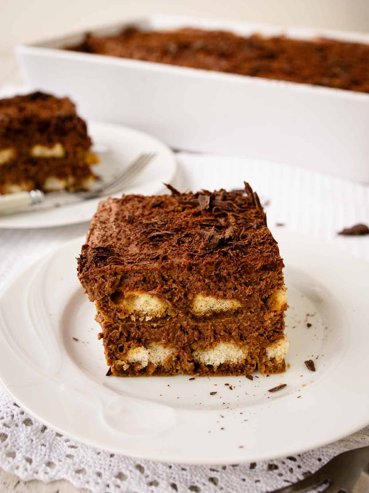 Large square piece of Chocolate Tiramisu on a white plate.