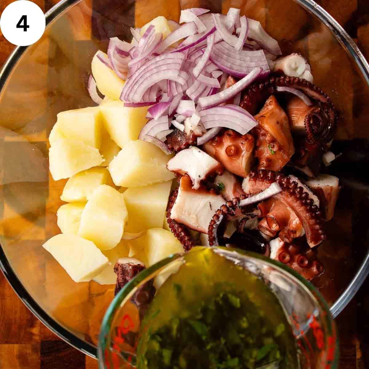 Pouring oily liquid onto cubes potatoes, cooked pieces of octopus and sliced red onion.
