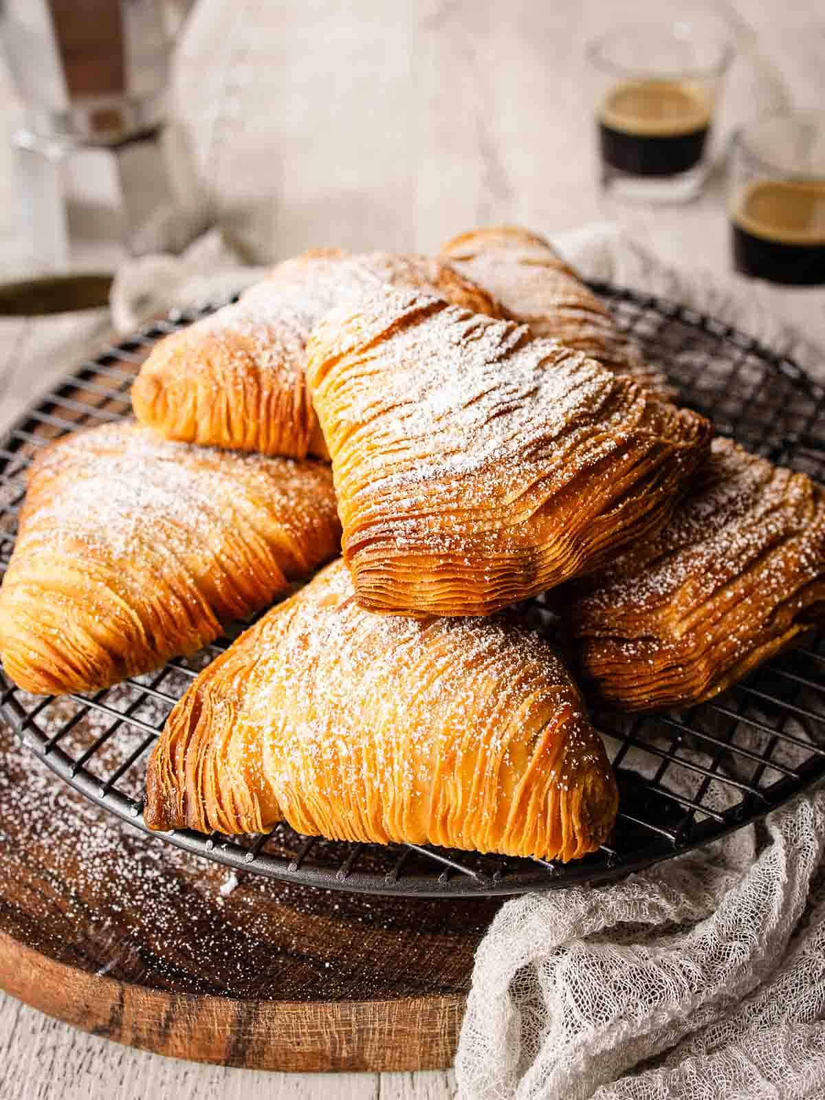 Flaky Sfogliatelle piled onto a round wire rack.