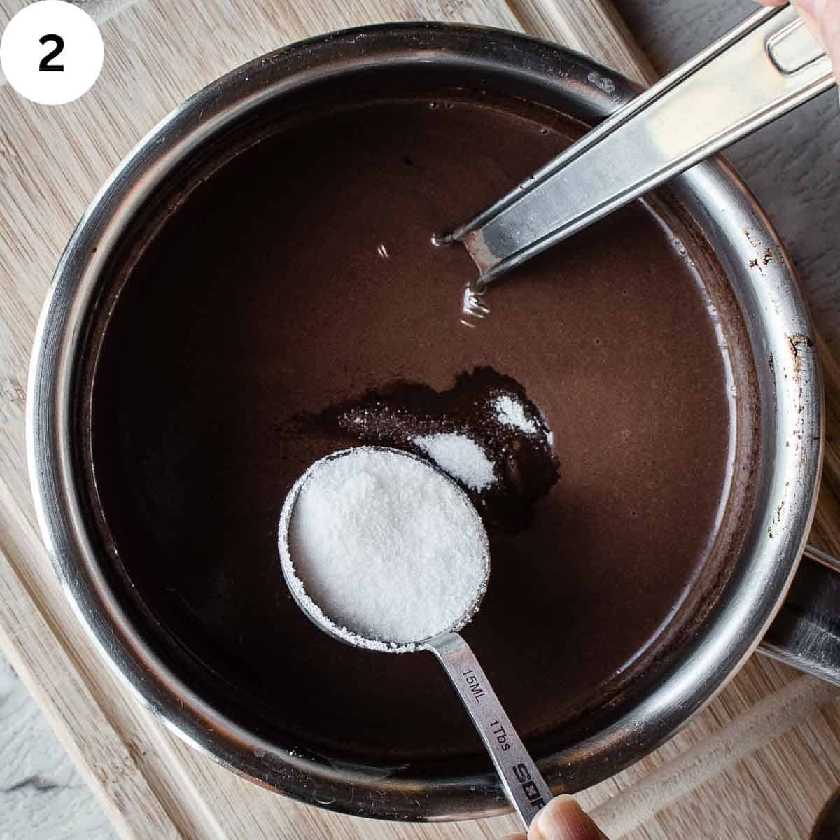 Adding a spoonful of sugar to chocolate mixture.