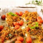 Baked Swordfish with a gratin topping surrounded by baked cherry tomatoes.