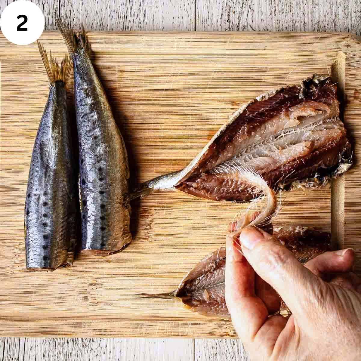 Peeling the back bone off butterflied sardines.