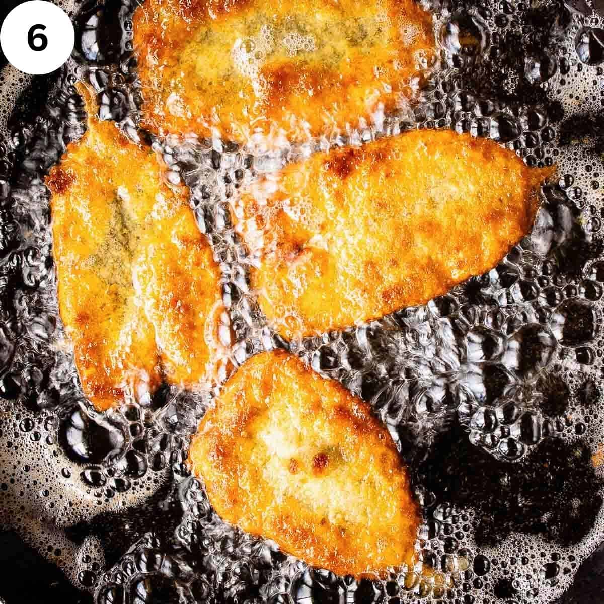 Breaded fresh sardines frying in oil.