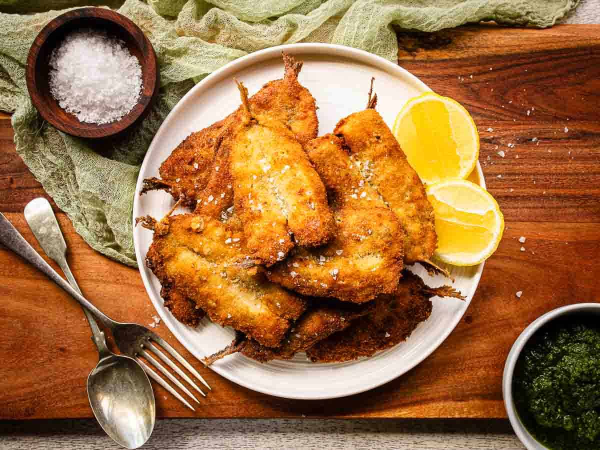 Overhead view of breaded sardines that have been fried until crisp.