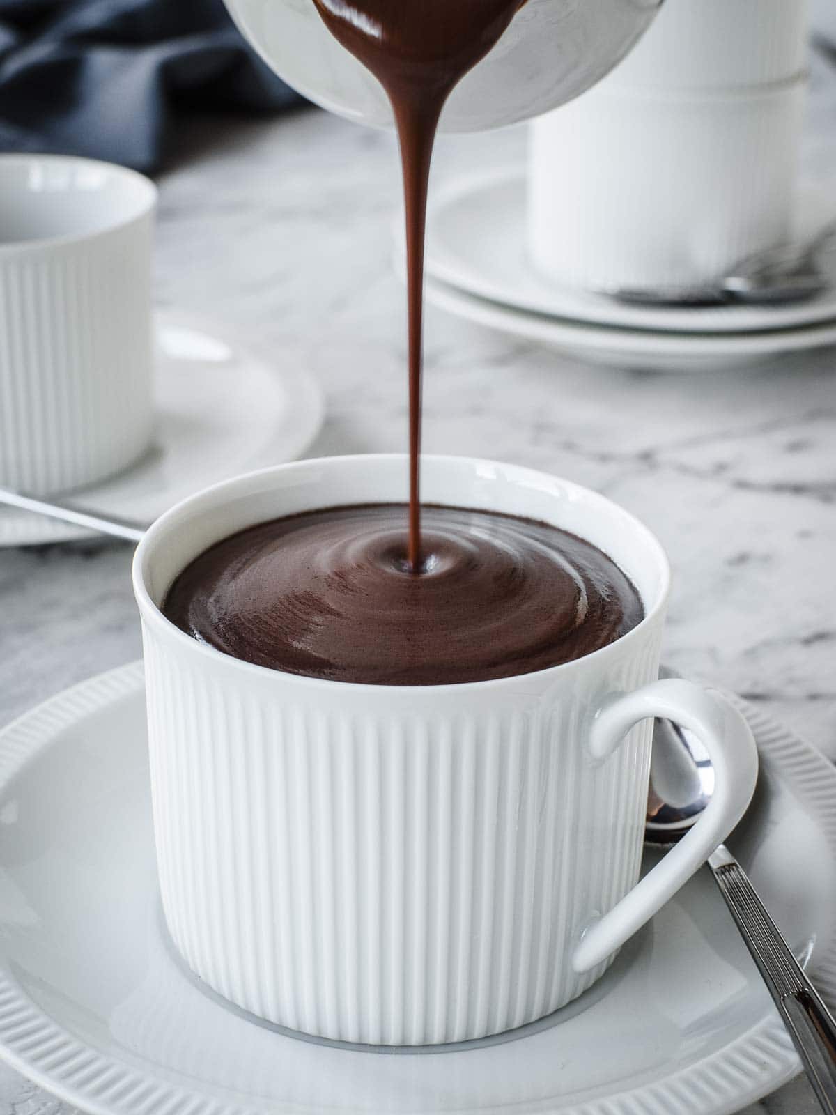 Italian Hot Chocolate being poured from a jug into a cup.