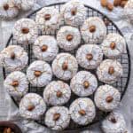 Amaretti Cookies on a round wire rack viewed from above. 3 cups (288 grams) ground almonds 3 egg whites 1 ¼ cup (250 grams) granulated white sugar 1 teaspoon almond extract Powdered sugar Almonds for decorating Prepare two baking sheets by lining them with parchment paper and preheat the oven to 350ºF/180°C. Combine the ground almonds with the sugar in a large bowl. Whip the egg whites until foamy with a fork. Whisk in the almond extract. Then add the egg whites and almond extract mixture. Stir until it becomes too difficult then use your hand to knead into a soft dough. Cover with plastic wrap and rest the mixture for 1 hour. Roll a tablespoon of the mixture into balls. Then roll in granulated sugar followed by powdered sugar. Arrange on a prepared baking sheet. Press down with two fingers to slightly flatten. Insert an almond, if using. Bake in a preheated oven at 350ºF/180°C for about 15 minutes, as they swell and darken remove the soft amaretti from the oven. Allow to cool for 10 minutes before transferring to a wire rack to cool completely. Store in an airtight container.