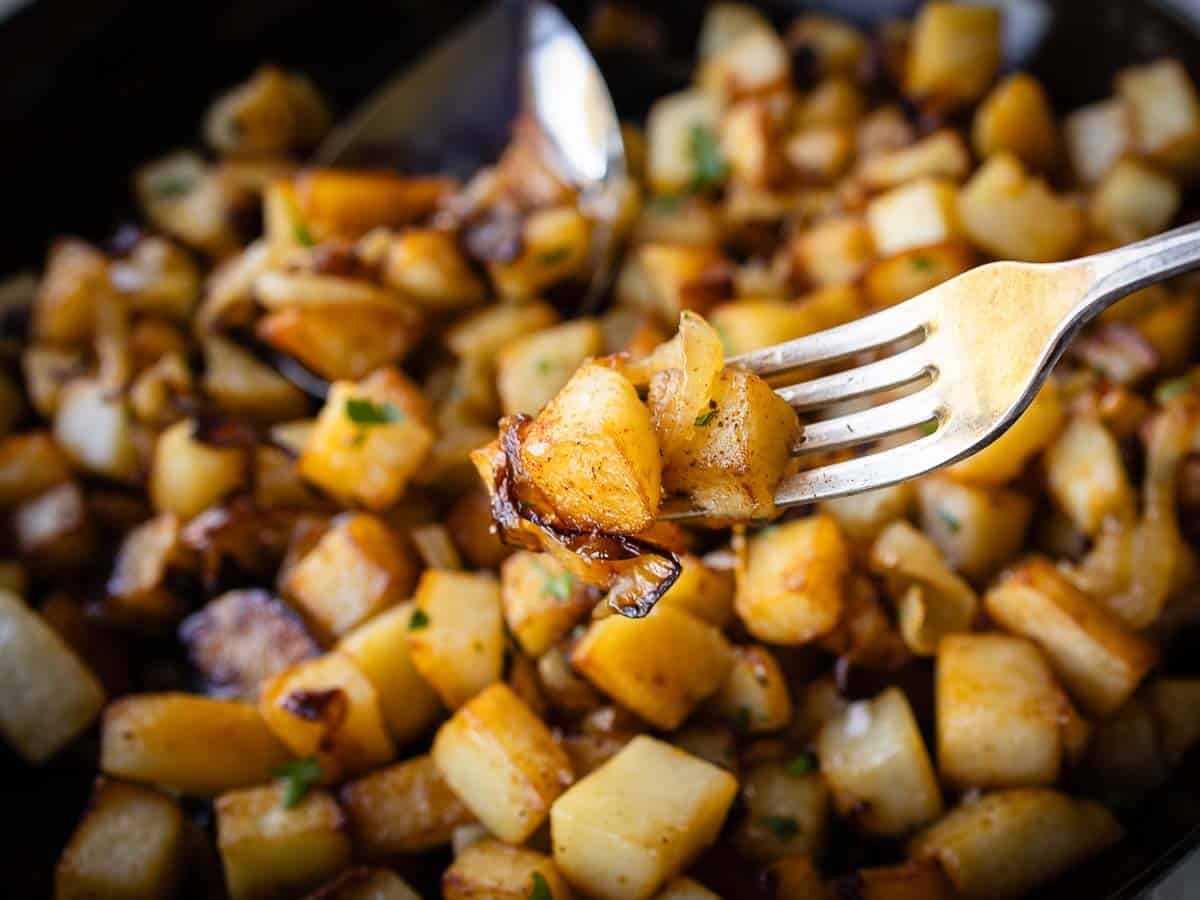 Close up of fried potatoes on a fork.