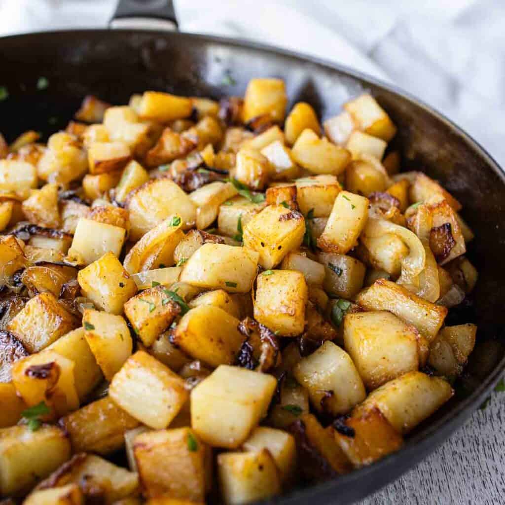 Fried potatoes and onions in a skillet.