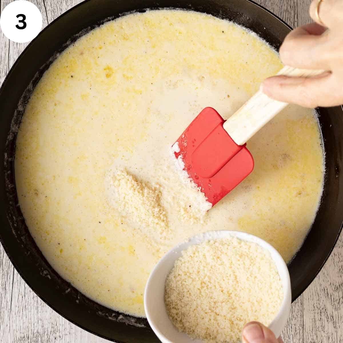 Grated Parmesan cheese added to cream in a skillet.