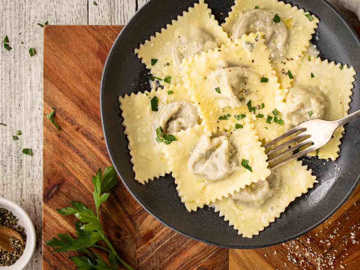 Homemade ravioli in a shallow bowl viewed overhead.