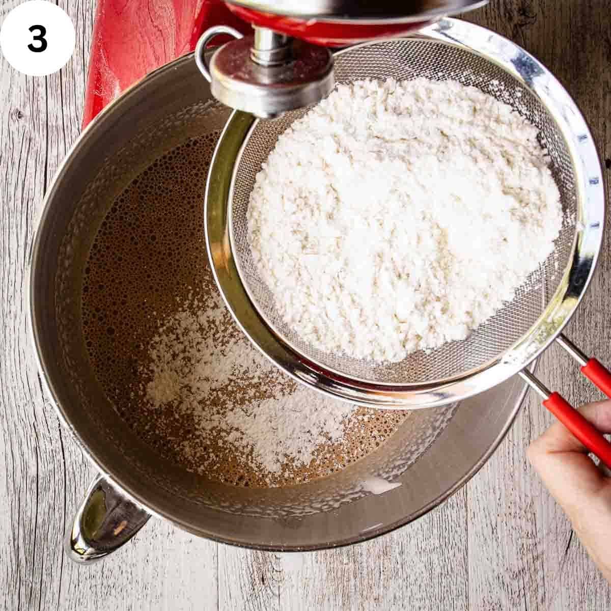 Flour in a sieve over the bowl of stand mixer.