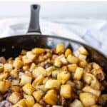 Fried potatoes and onions in a skillet.