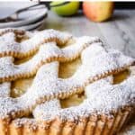 Apple crostata with lattice top crust dusted with powdered sugar.