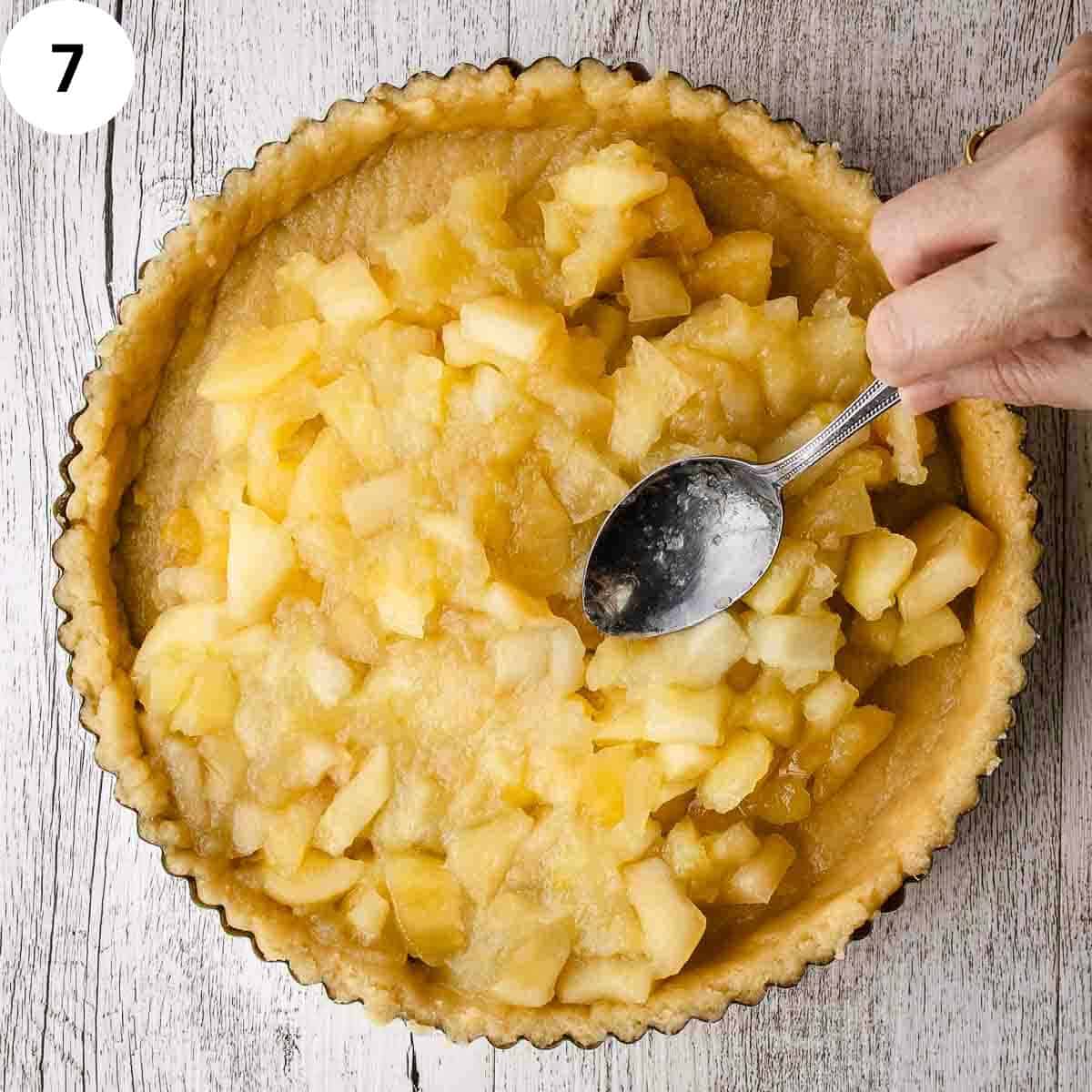 Spreading apples into a pastry lined pan.