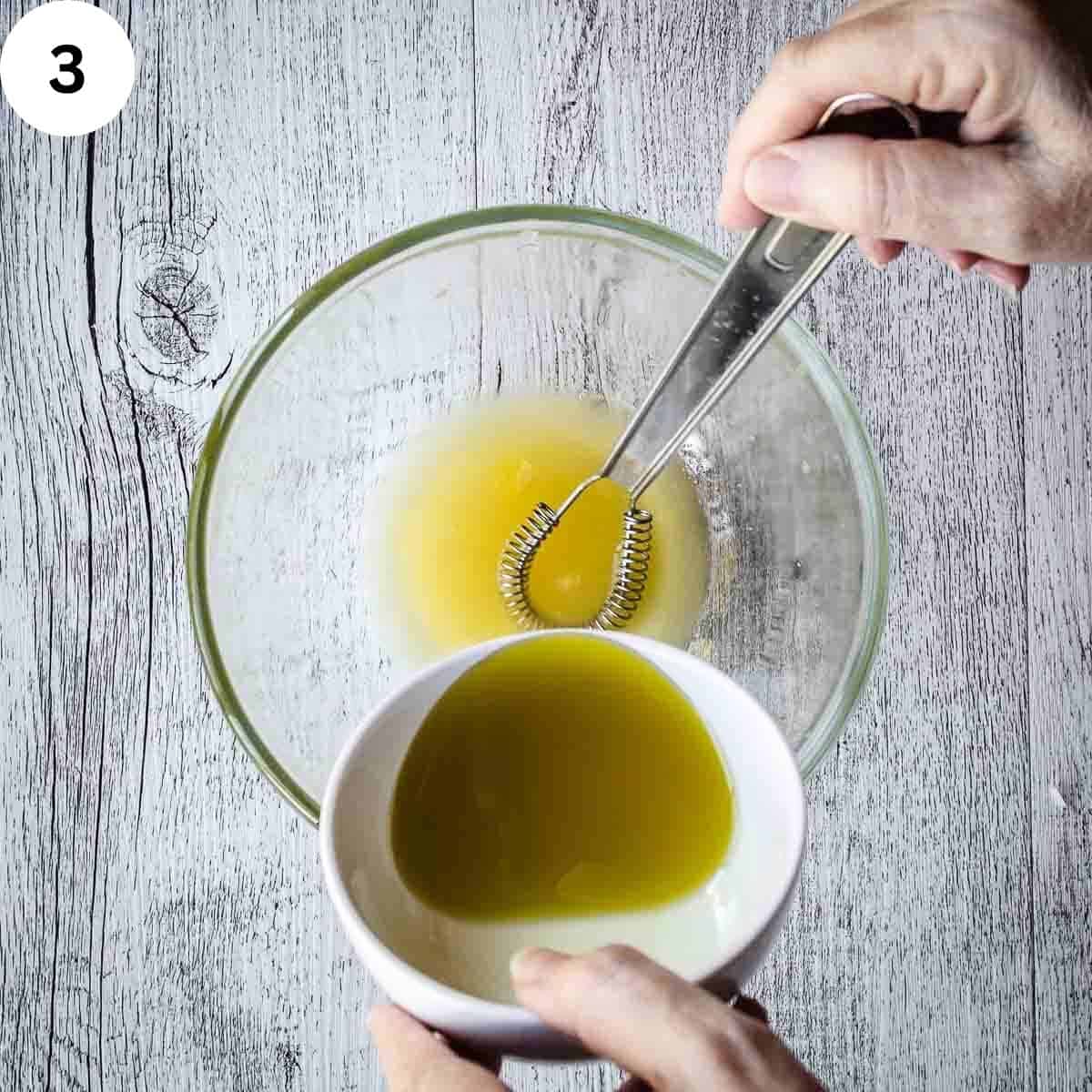 Whisking oil into orange juice.