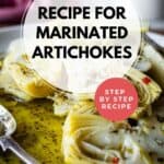 Close up of marinated artichokes plied onto a plate.