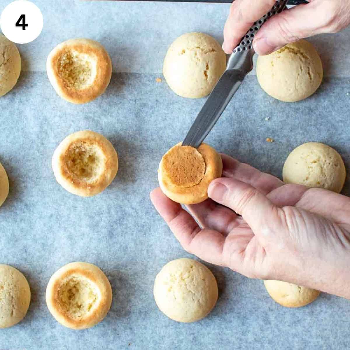 Using a knife to scoop out a hole in the base of cookies.
